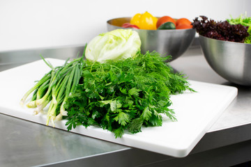 Fresh greens and vegetables on the kitchen table
