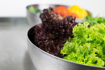 Fresh salad and vegetables in metal bowls