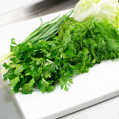 Parsley, onion, dill and cabbage on a cutting board