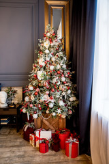 Beautiful holdiay decorated room with Christmas tree with presents under it. New Year decorated classic home interior. cozy room ready to celebrate Christmas. Christmas interior design, Xmas tree