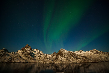 Fototapeta na wymiar beautiful aurora borealis, polar lights, over mountains in the North of Europe - Lofoten islands, Norway