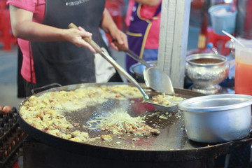 Chef cooking fried clams in big pan, Thai food. Dish, roasted.