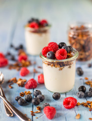 Vasetto di yogurt con frutta secca e frutti di bosco in primo piano