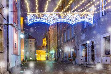 Royal Castle and beautiful street in Old Town at snowy night , Warsaw, Poland.