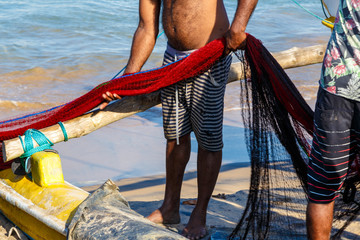 fishermen with red nets on the shore of the ocean, Galle Sri Lanka. - Powered by Adobe