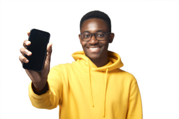 young black man in yellow hoodie with phone