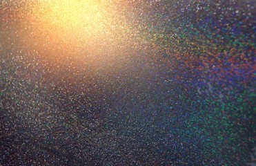 Wonderful spectrum iridescent glitter pattern. Bright golden shine on dark silver background. Abstract illustration. Blurred texture. Rainbow shimmer.