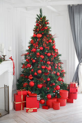 Christmas, New Year white interior with decorated fir tree, red balls, red gifts boxes, grey curtains