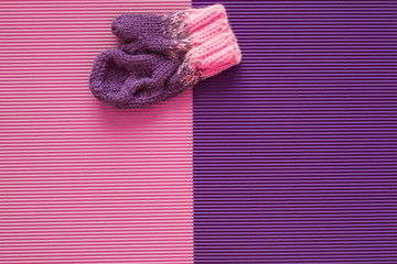 Children's winter mitten is on a pink and purple background. Handmade.