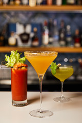 selective focus of mixed and fresh cocktails in glasses on bar counter