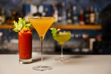 selective focus of cold and fresh cocktails in glasses on bar counter