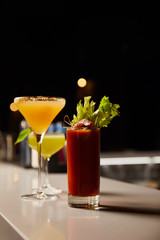 selective focus of cold and mixed cocktails in glasses on bar stand