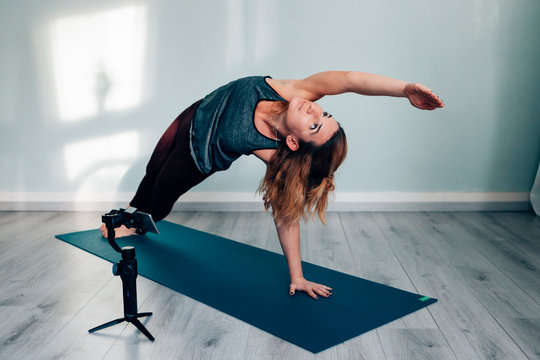 young woman in sportswear blogging and vlogging with a mobile phone and a gimbal - influencer and digital nomad concept - Powered by Adobe