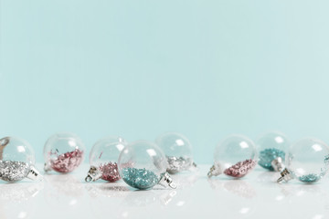 Christmas composition. Frame made of balls and snowflakes on pastel blue background.