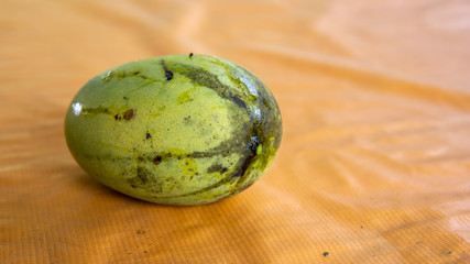 Close up view of fully ripped mango on a orange table background.