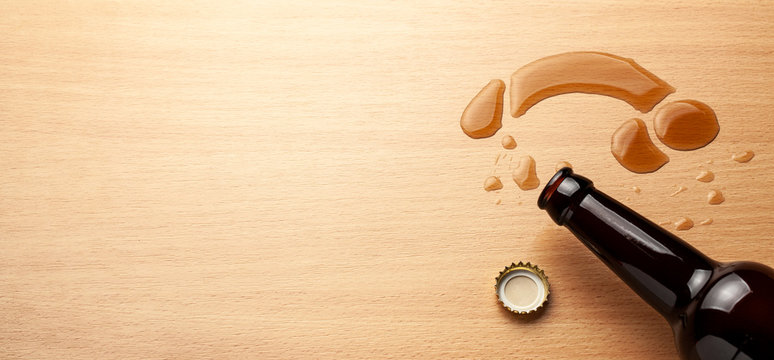 Impotence from alcohol. Beer bottle and beer spilled in the shape of penis