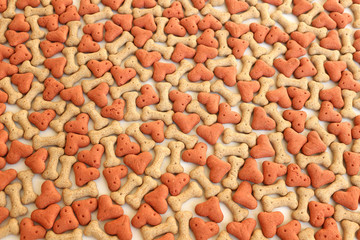 Bone and heart shaped dog biscuits. Dog treat background.