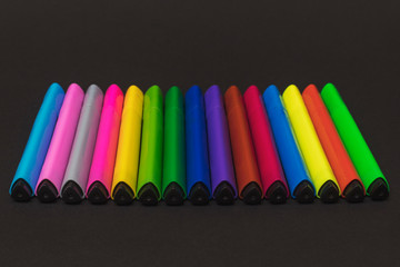 Colorful triangular markers lie in a row on a black paper background. 