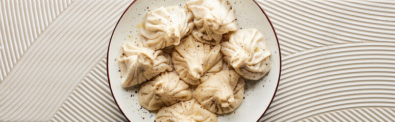 top view of fresh delicious khinkali on textured beige background, panoramic shot