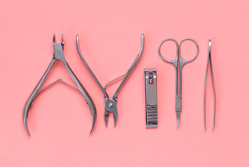 Set of manicure and pedicure tools on pink background. Instrument for nail care: clippers, scissor,...