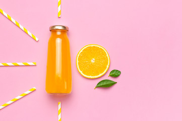 Flat lay composition with glass bottles of juice or fresh, slices of fresh lemon and orange, green...
