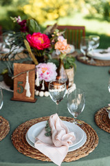 Festive table setting. Plates decorated with eucalyptus branches and elegant napkins in nude colors.
