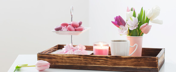 Tulips in vase and cup of coffee with dessert on white background. Concept woman's or mother's day