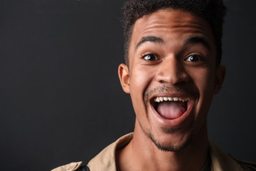 Photo of excited african american man smiling and looking at camera