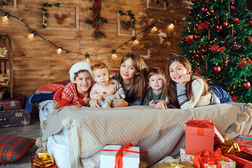 Mother with children lie on the bed at Christmas