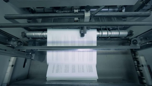 Printed paper stacked on a typography line, automated machine.