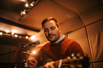 Close-up portrait of a man enjoy playing guitar.