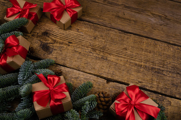 Merry Christmas textured wooden background close view brown boxes with red bows and holiday toys. Place for text or design.