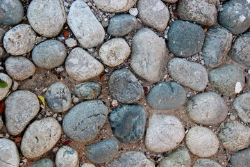 Closeup of an old pebblestone road cobbled with natural stones