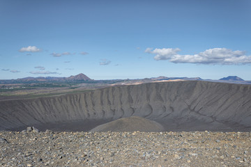 Giant volcano crater, dark sand dunes and sulphur dust desert., blue sky