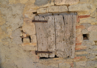 Altes verwittertes Holzfenster in einem Natursteinhaus in Italien