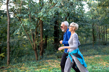 Fototapeta na wymiar Mature couple man and woman jogging in the park