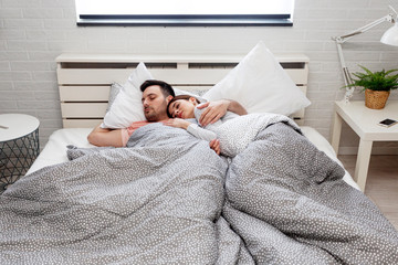 Couple sleeping in bed in bedroom