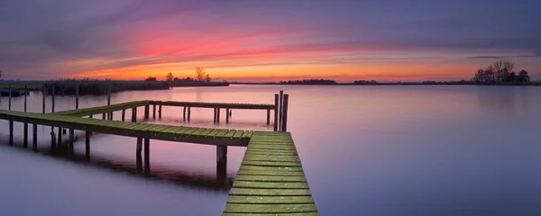 Foto op Canvas Old jetty on a lake at sunset © sara_winter