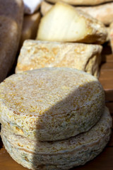 Large selection of cheese varieties on a wooden table background.