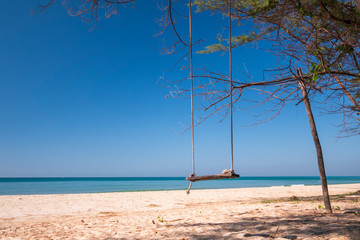 Beautiful tropical sea background swing on the sand beach with blue sky in sunny day