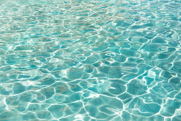 Fototapeta na wymiar Turquoise blue water in swimming pool background, sun reflection, clear clean water, shining water ripple background, Aqua texture, pattern