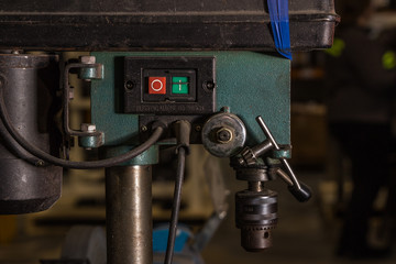 Dirt Machine used for drilling and tapping electrically operated with green and red buttons for safety. Retro vintage old machine covered in dirt grime and oil still being used for production