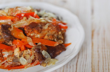 rabbit stew with vegetables on a white rustic wooden table