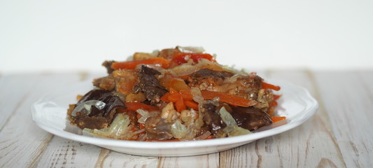 rabbit stew with vegetables on a white rustic wooden table