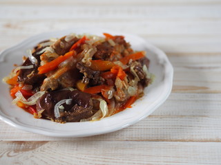 rabbit stew with vegetables on a white rustic wooden table
