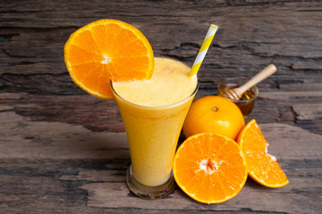 Orange smoothies orange colorful fruit juice beverage healthy high protein the taste yummy in glass on wood background from top view.