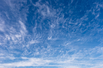 Naklejka na ściany i meble Beautiful spindrift clouds on a blue autumn sky in a frosty day.