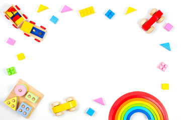 Baby kids toys background. Wooden educational geometric stacking blocks toy, wooden train, car, rainbow, airplane and colorful blocks on white background. Top view, flat lay