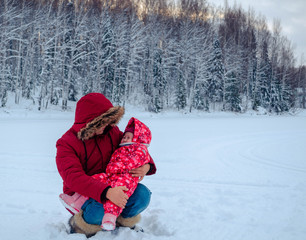 Fototapeta na wymiar Asian dad and his little cute daughter in red have fun outdoors in winter. Walk through the winter snow-white forest. happy baby love family. New year and Christmas in Siberia.