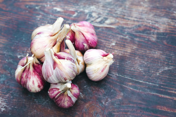 Fresh garlic crop on old wooden table, close-up